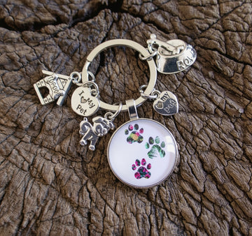 Keychain with paw print design on a textured brown surface